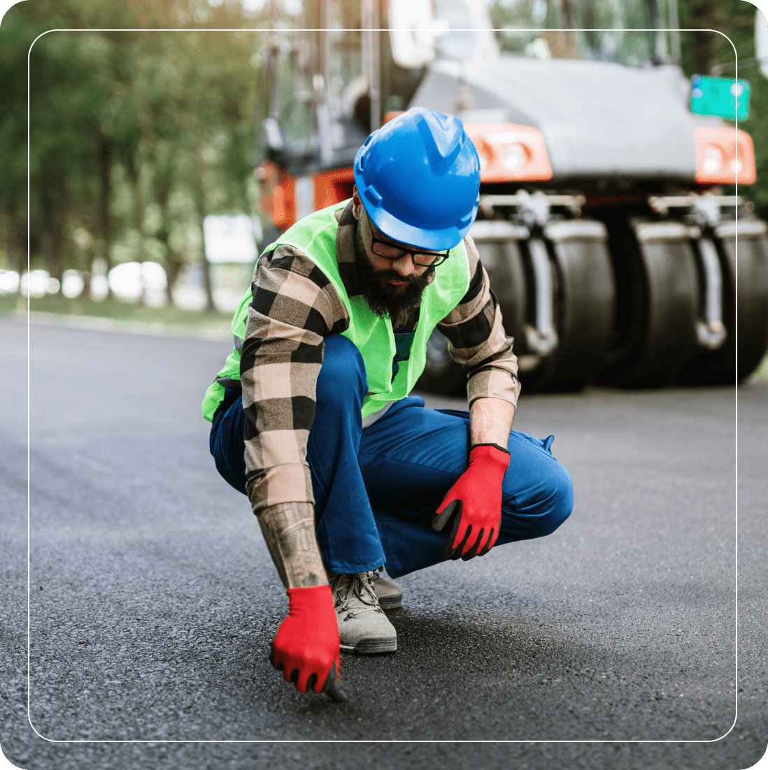 Worker inspecting newly paved road surface.